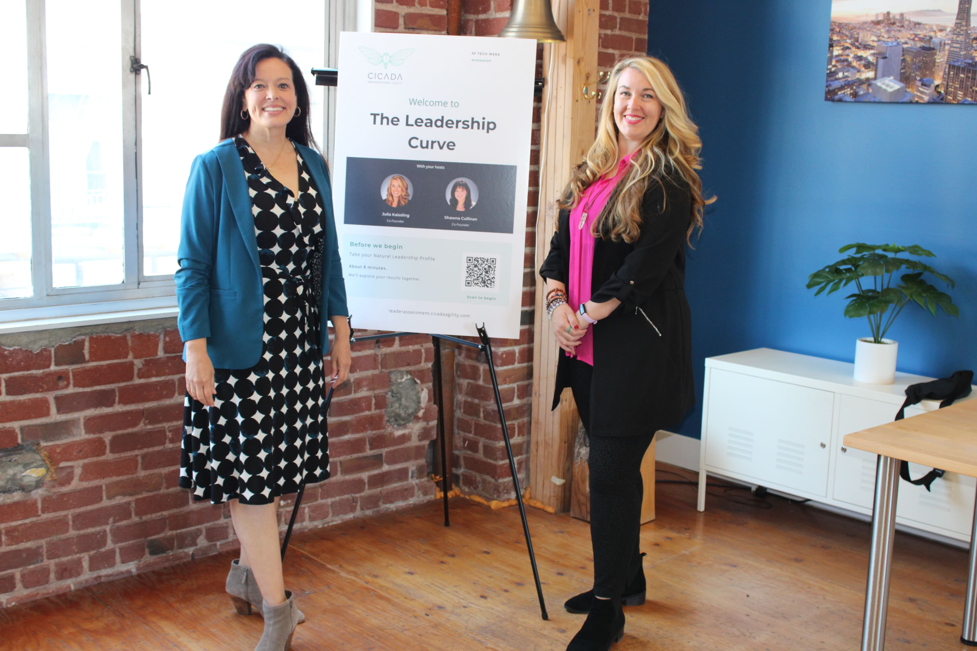 Cicada business partners standing in front of their SF Tech Week event poster